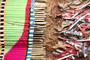 A colourful woven textile next to shredded Tim Horton's cups