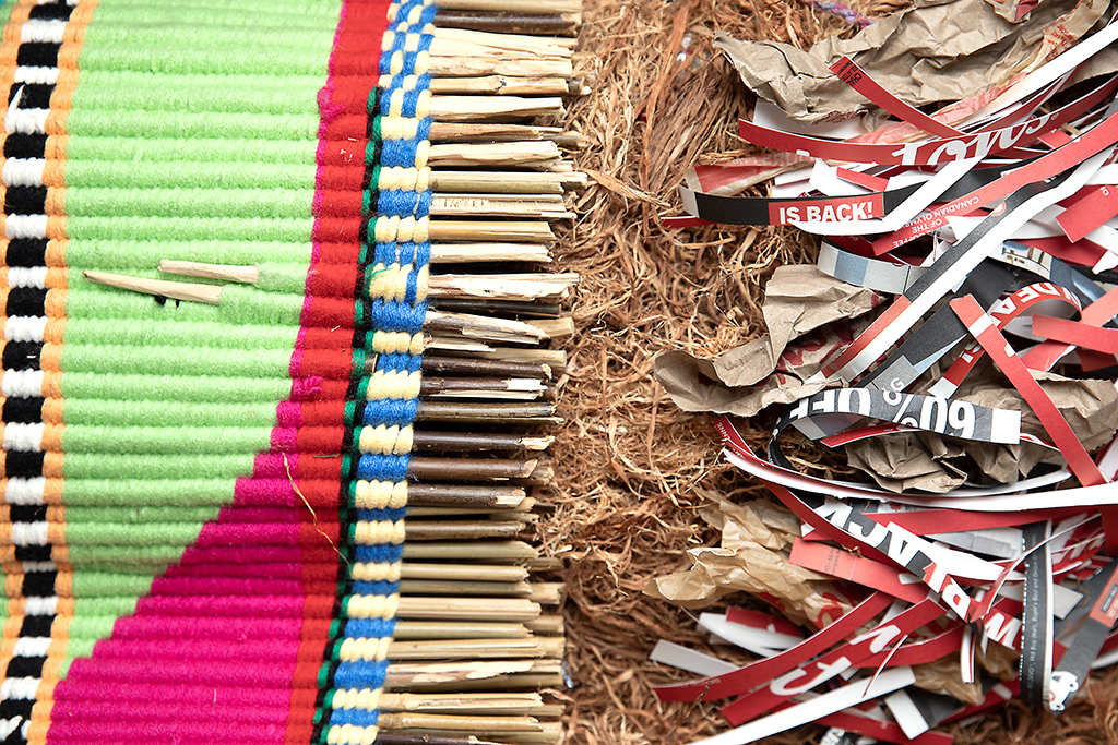 A colourful woven textile next to shredded Tim Horton's cups