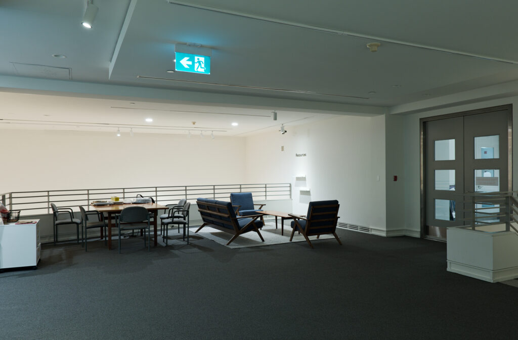 CUAG's mezzanine level entrance with casual seating for visitors including a work table and art supplies cabinet